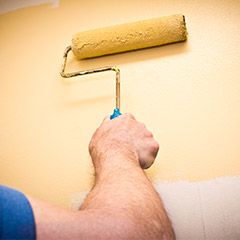 Paint roller applying yellow paint