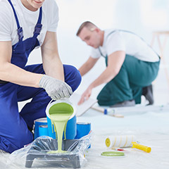 Two men painting interior walls