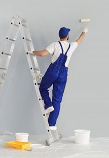 a contractor painting the interior walls of a house