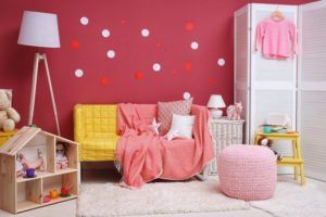 child's room with a red wall and a couch 