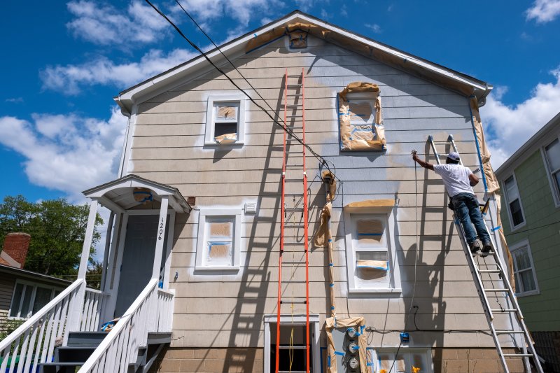 man prepping the outside of home