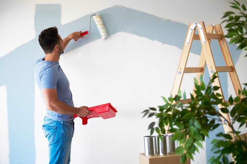 man painting the inside of his home 