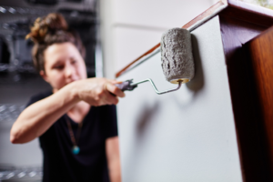 a person painting their kitchen cabinets 