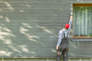 a person painting an exterior surface